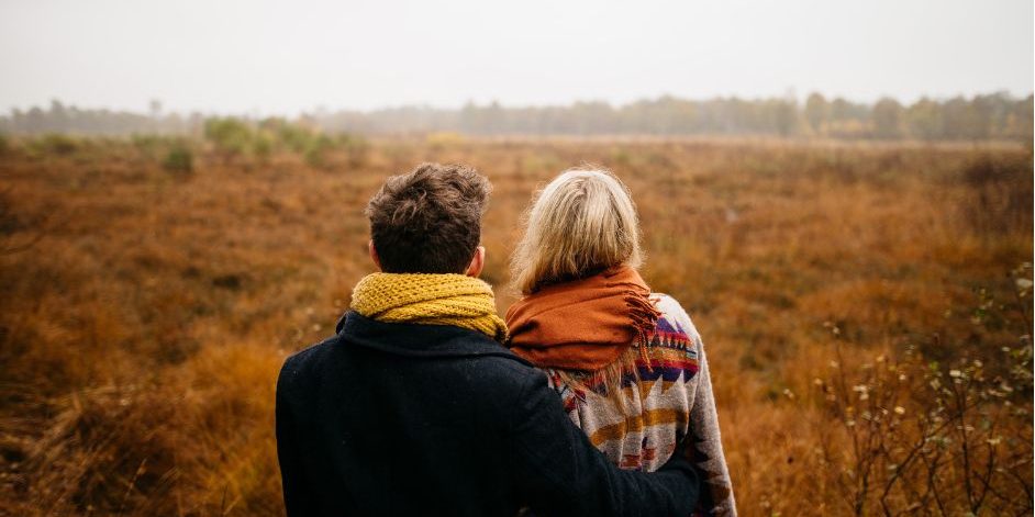 couple looking out onto field of grass couple looking out onto field of grass
